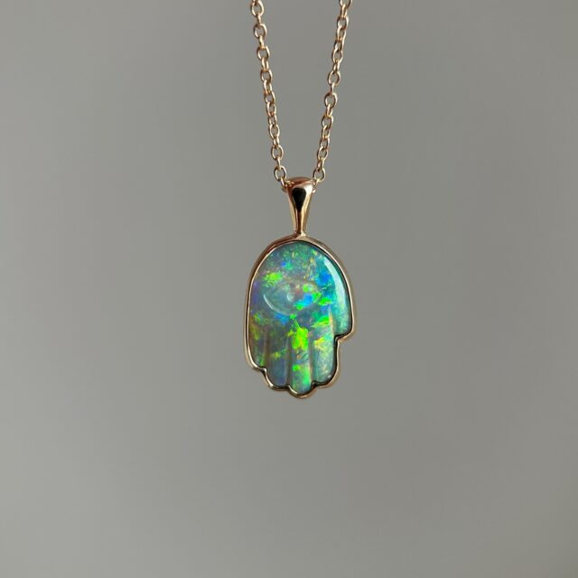 14K Yellow gold Hamsa Hand pendant with Australian Dark Opal 🪬 This opal shifts colors from peachy-orange and green to green and blue depending on the lighting. Available on our website {sold}